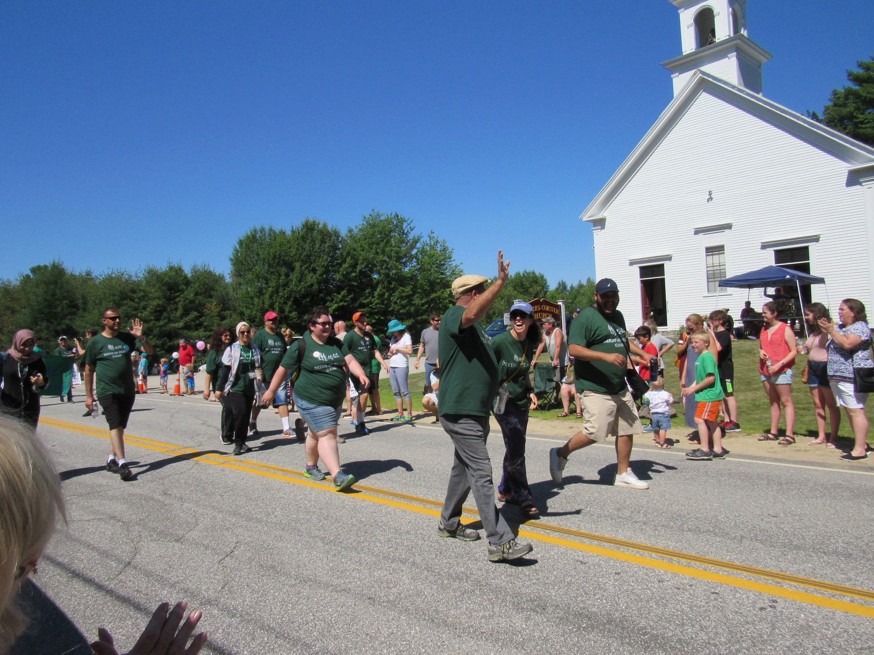 Parade marchers in green shirts at the Fourth of July parade.