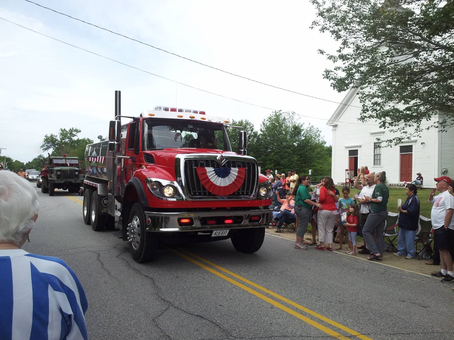 Fire tanker truck passing parade spectators at the Fourth of July parade.
