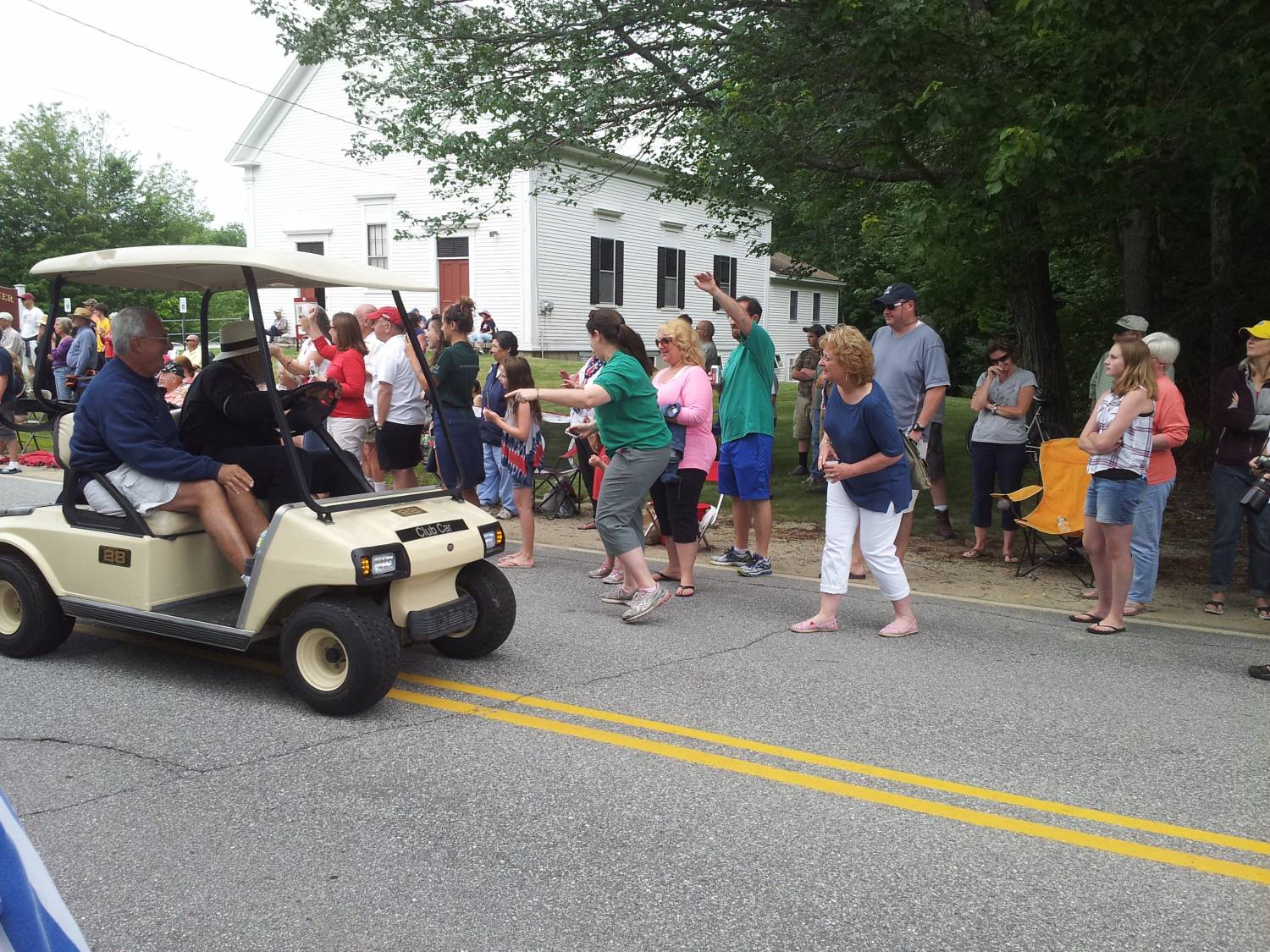 Golf cart passing parade spectators at the Fourth of July parade.