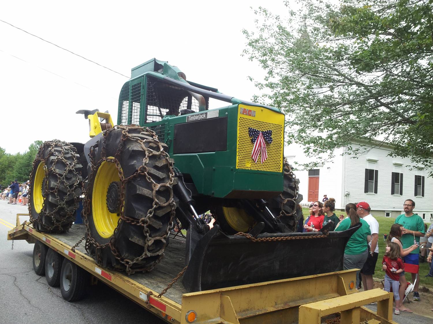 Timberjack logging skidder on a flatbed trailer at the Fourth of July parade.