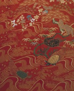 A silk kimono, circa 1850, showing resist-dyed work with stencils. Detail of a red silk kimono decorated with birds and foliage.