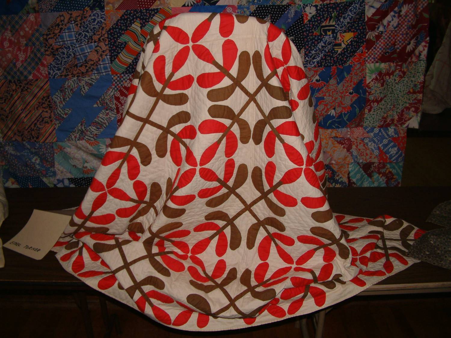 Ethel Turner-Elliot quilt with red and brown floral motifs.