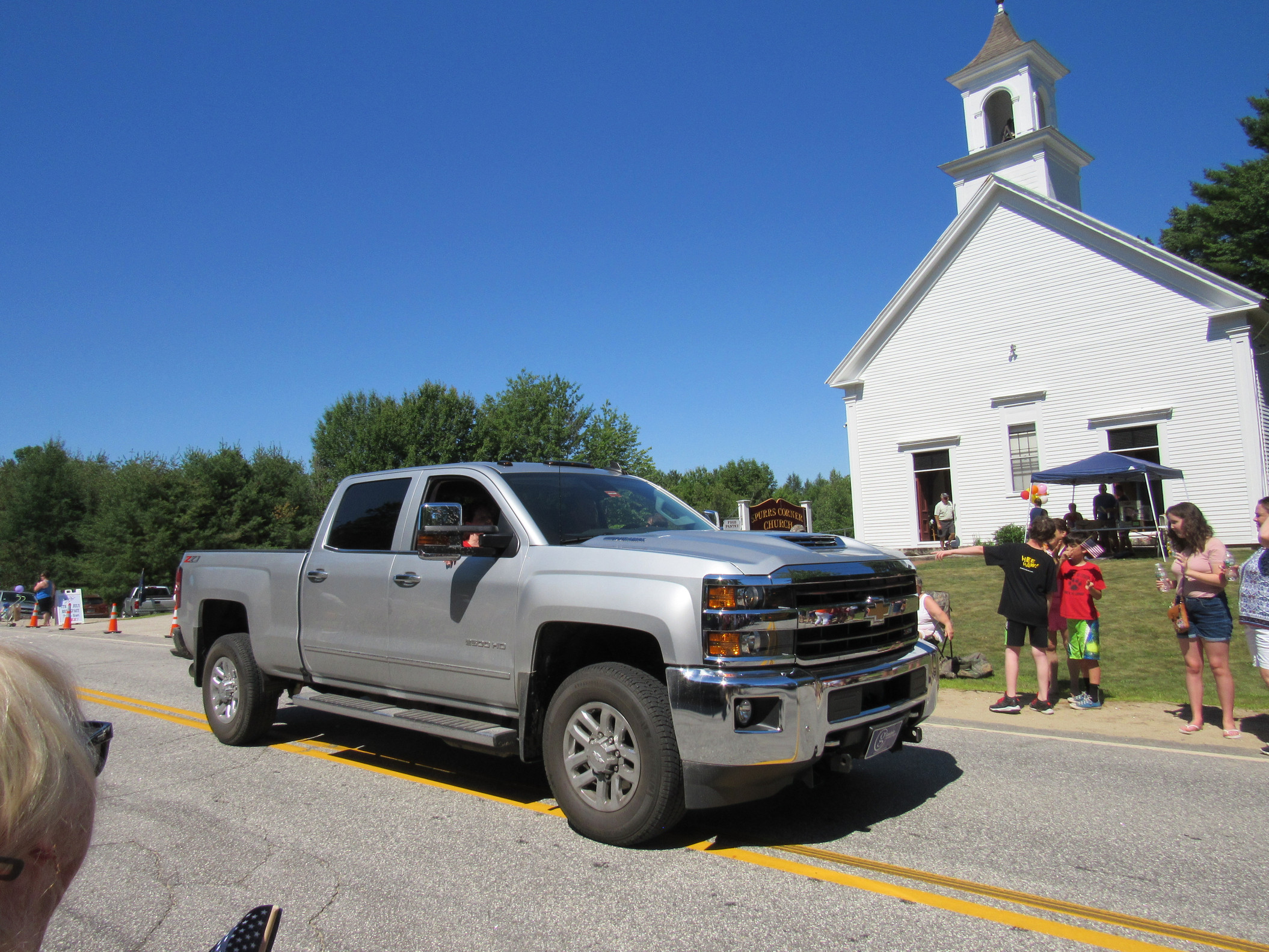 Pickup truck and visitors outside a meetinghouse