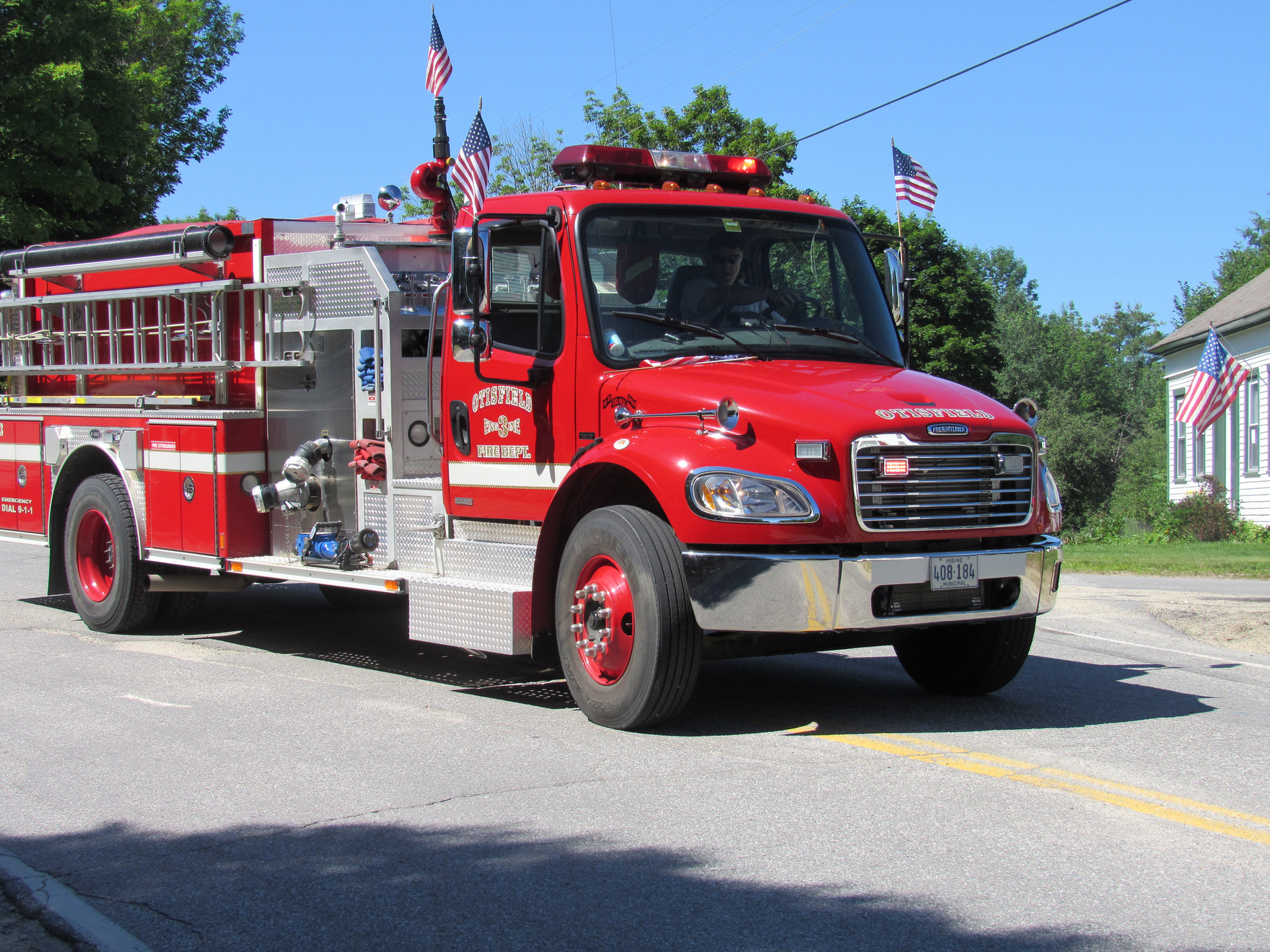 Red fire engine in the parade at the Fourth of July parade.
