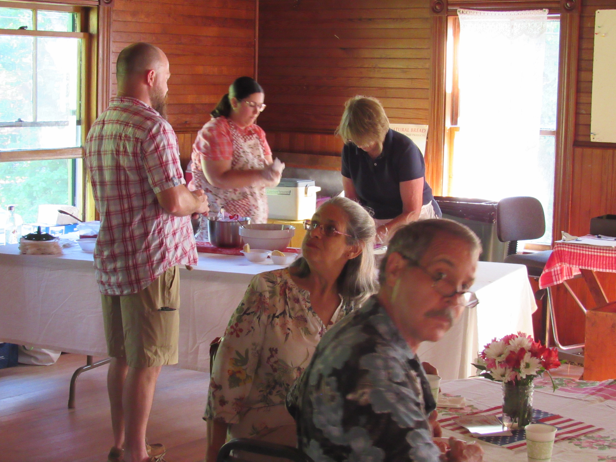 Directors Maureen Howard and Jess Dorr prepare shortcake for a patron at the 2019 Strawberry Festival
