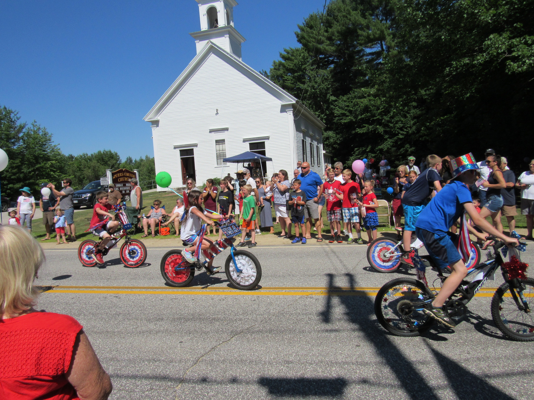 Decorated cycles passing parade spectators at the Fourth of July parade.