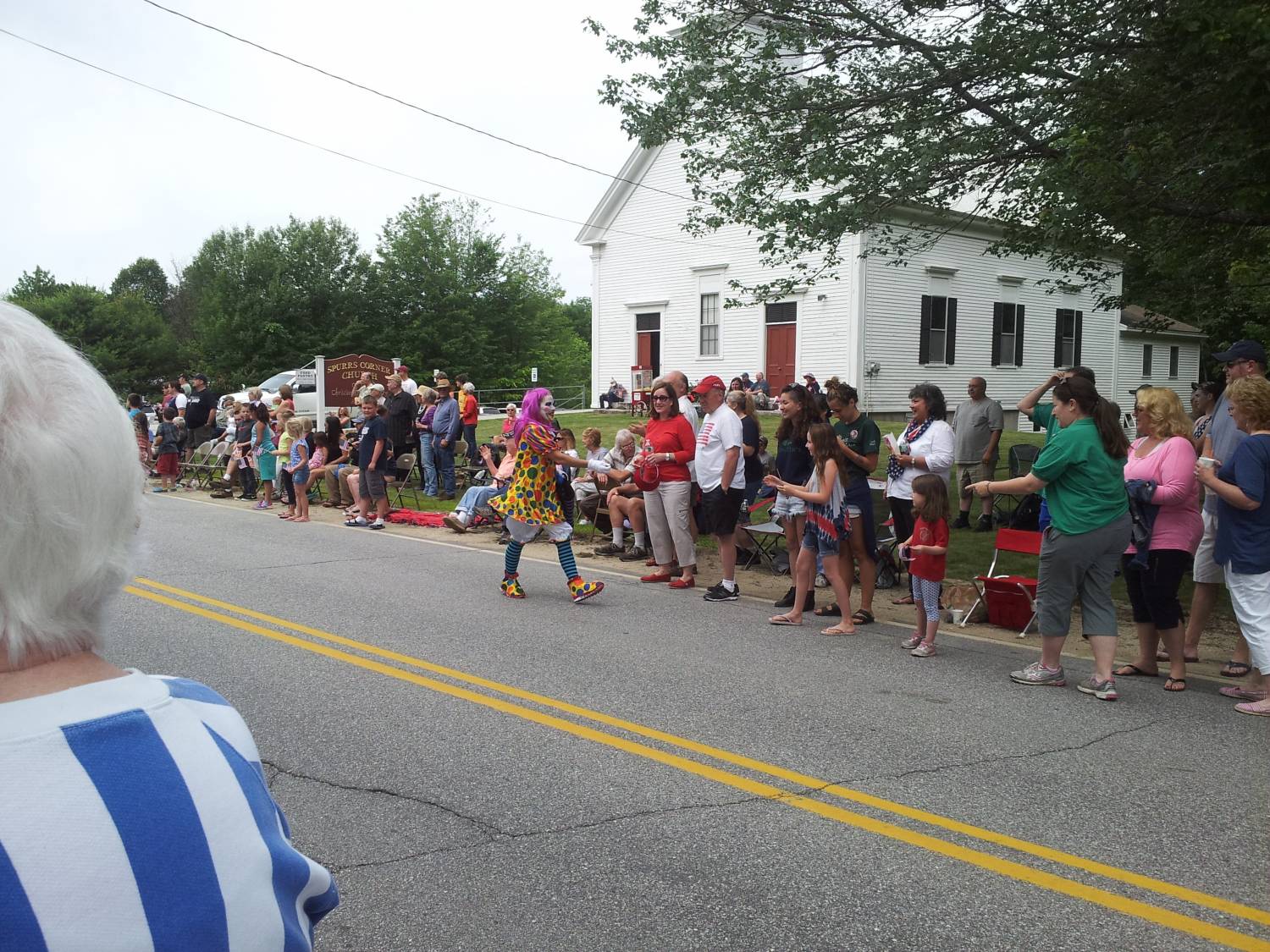 Costumed parade participant and roadside spectators at the Fourth of July parade.