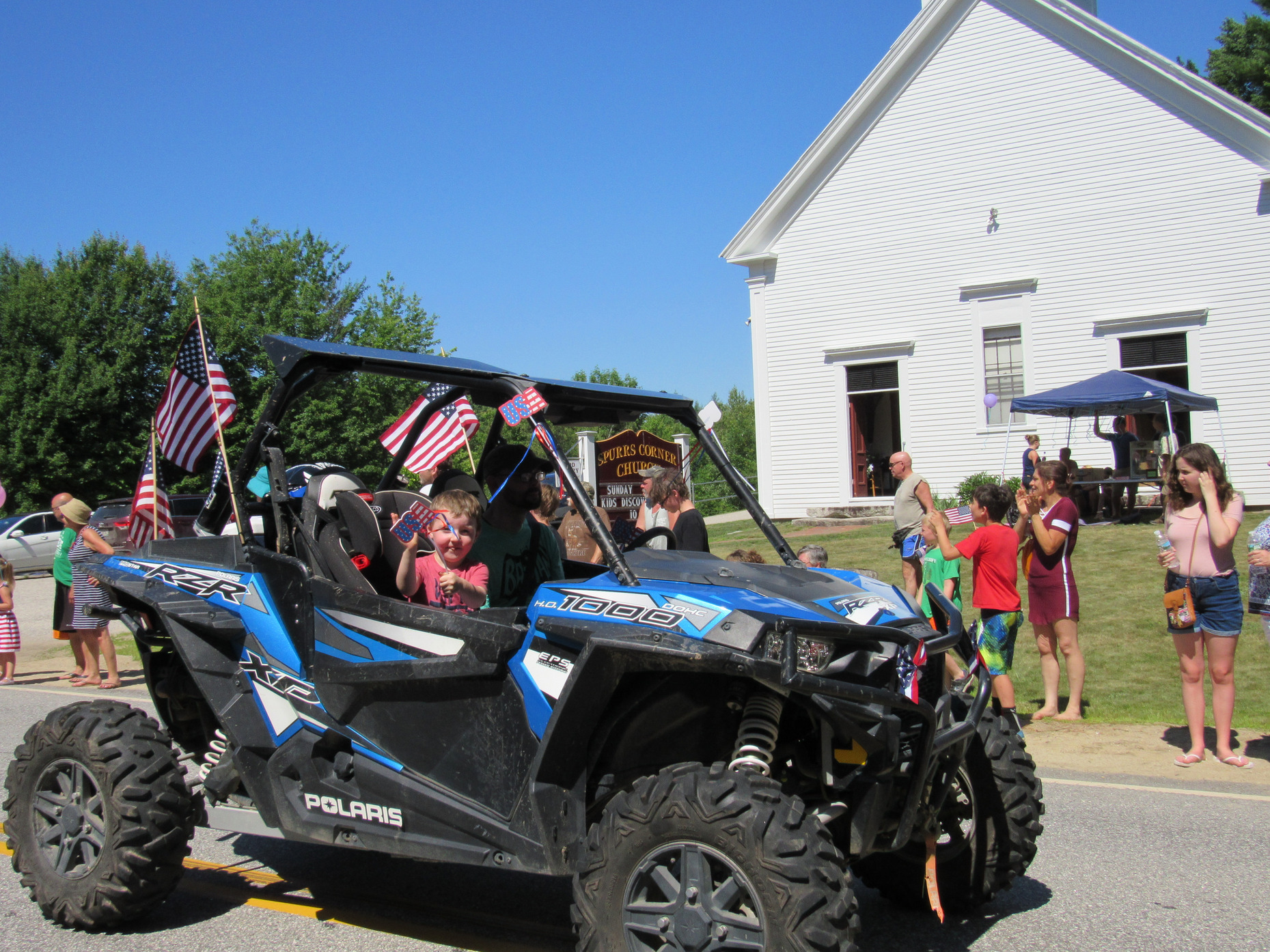 Side-by-side utility vehicle in the parade at the Fourth of July parade.