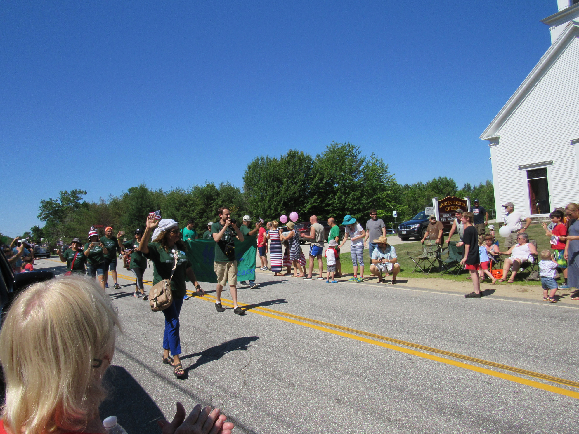 Parade marchers in green shirts at the Fourth of July parade.