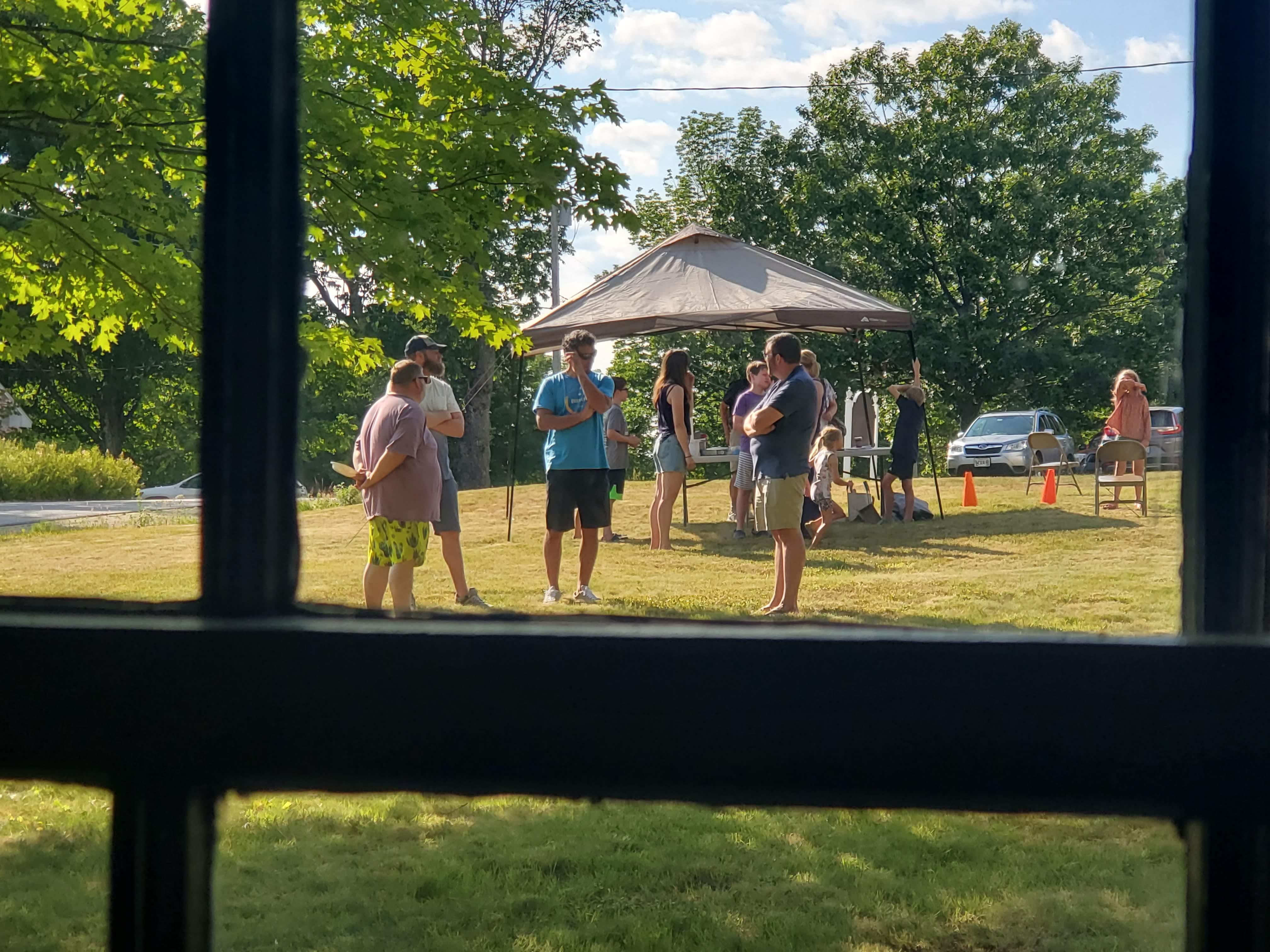 Outdoor gathering seen through a window