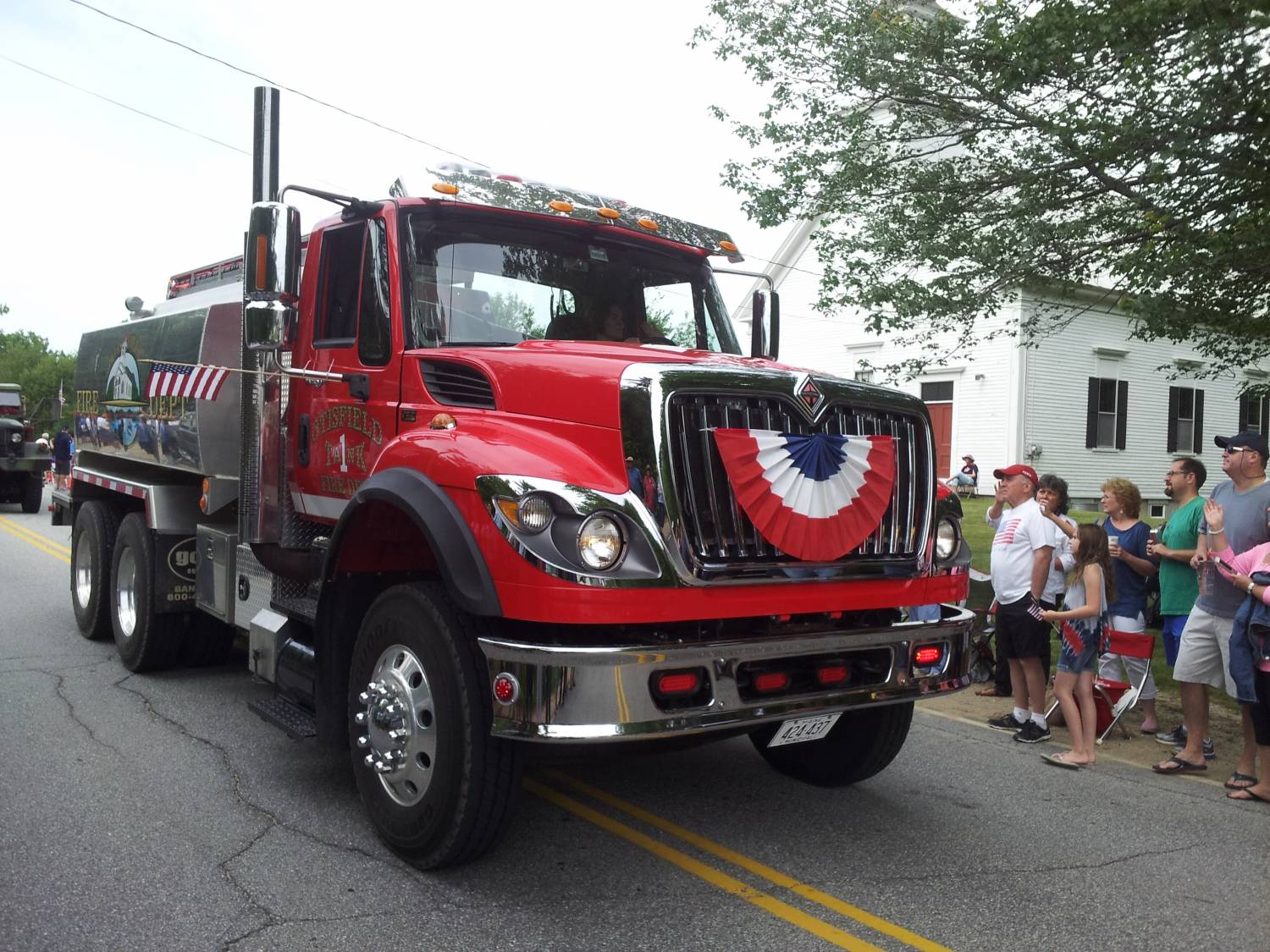 Fire tanker truck passing parade spectators at the Fourth of July parade.