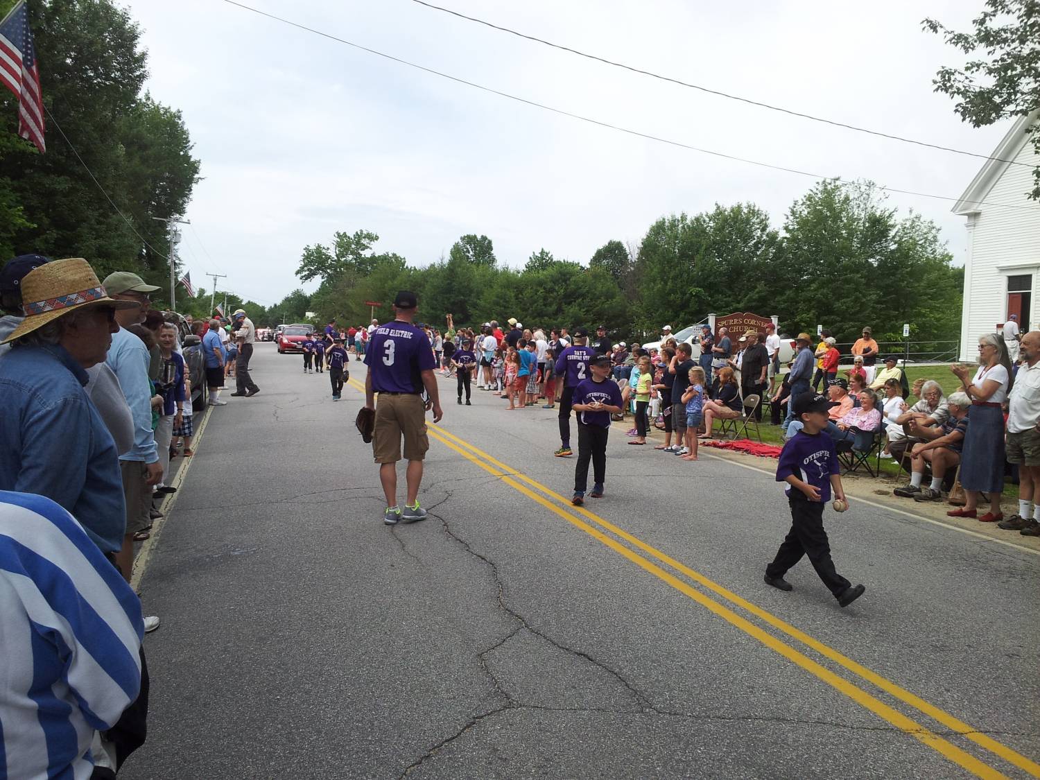 Young parade marchers wearing purple team jerseys at the Fourth of July parade.