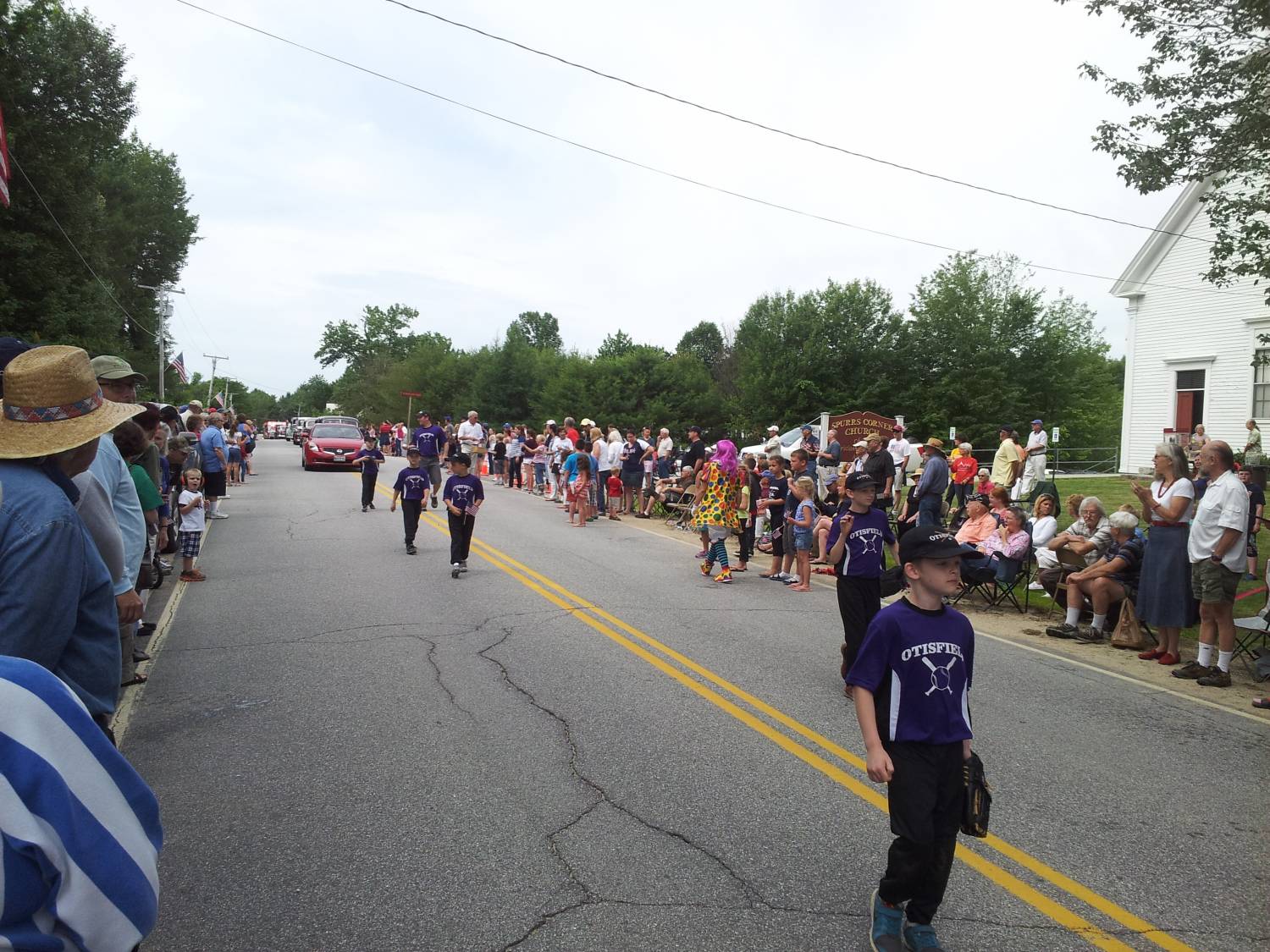 Young parade marchers wearing purple team jerseys at the Fourth of July parade.