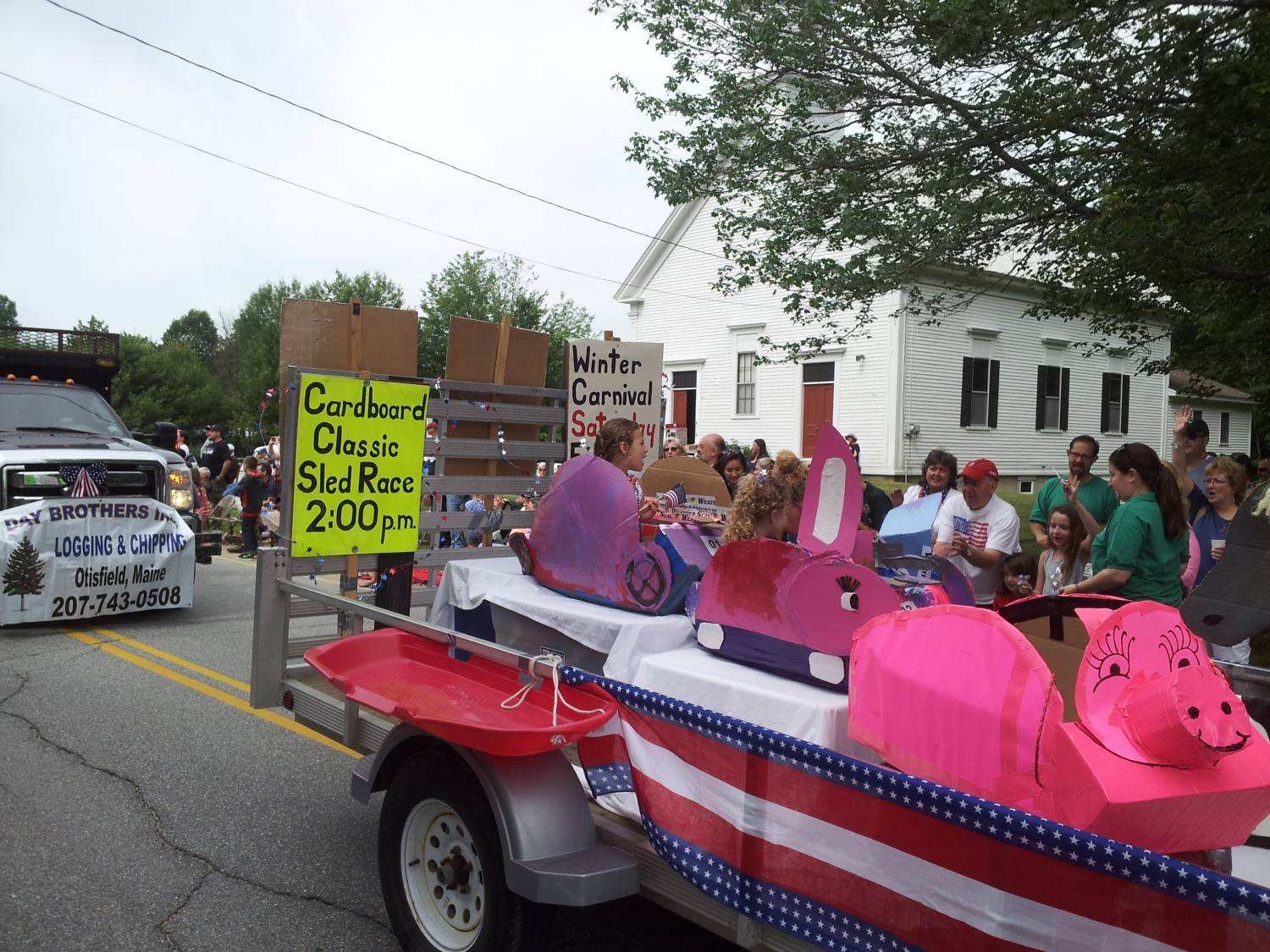 Winter Carnival float with cardboard sleds at the Fourth of July parade.