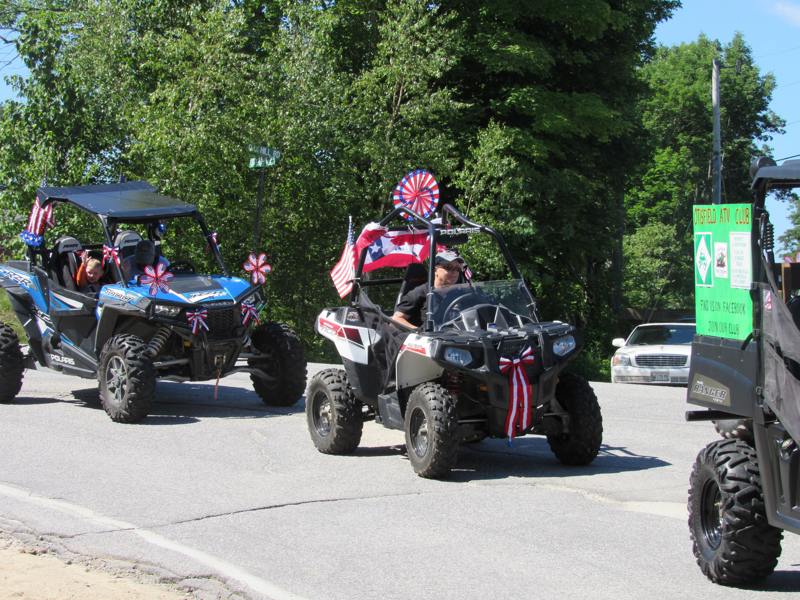 All-terrain vehicles with American flags at the Fourth of July parade.
