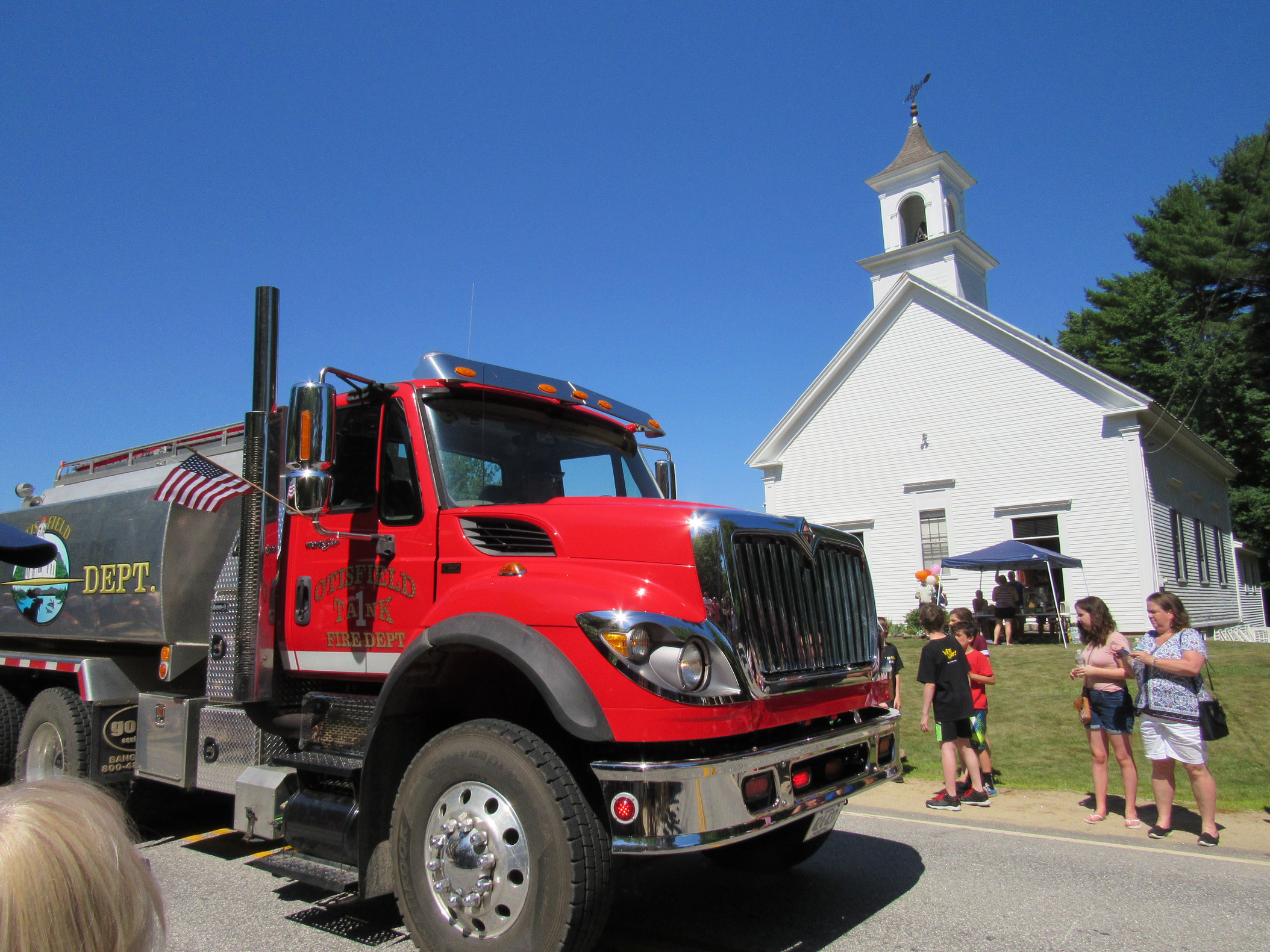 Fire tanker truck passing parade spectators at the Fourth of July parade.