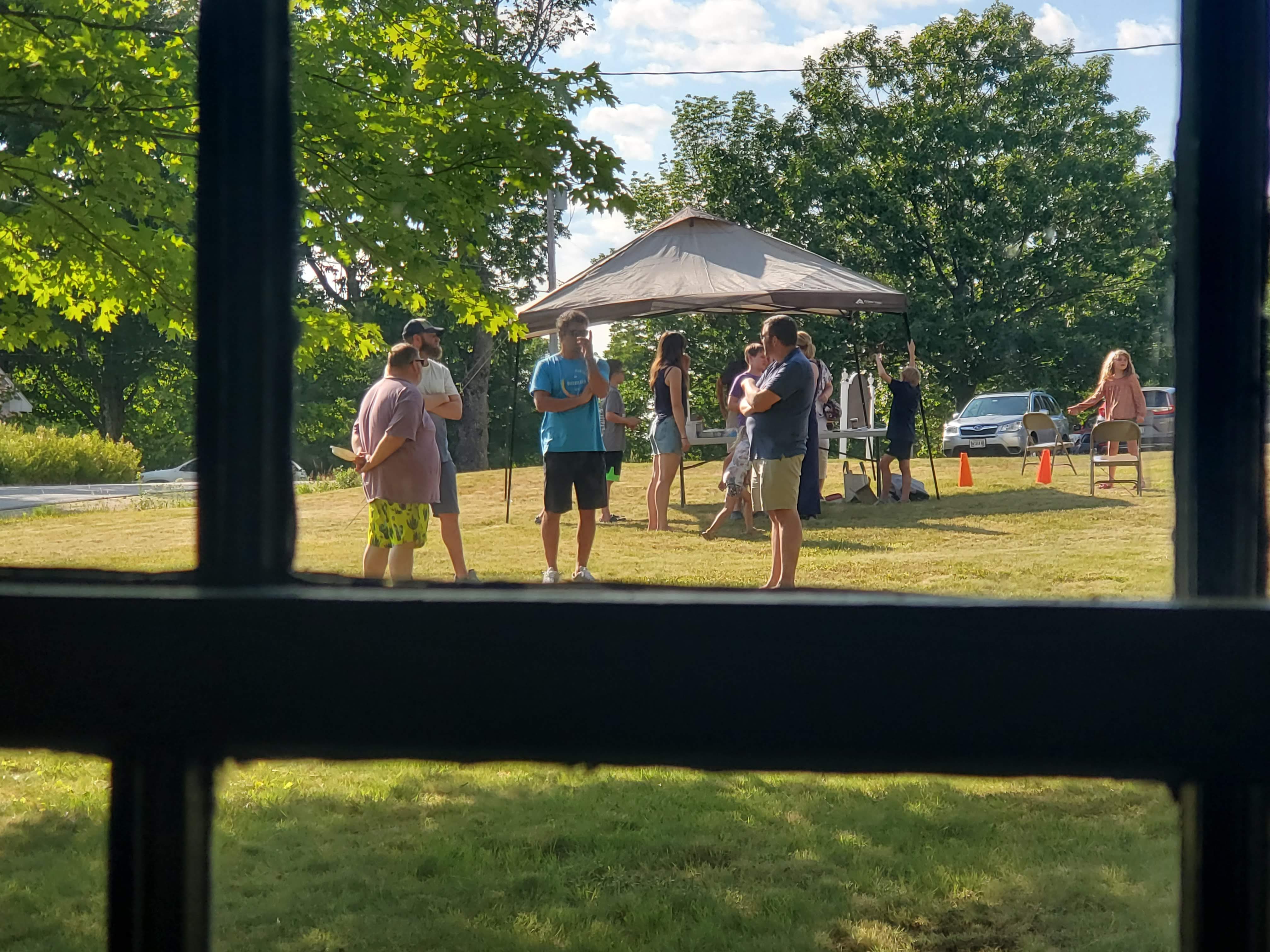 Outdoor gathering seen through a window