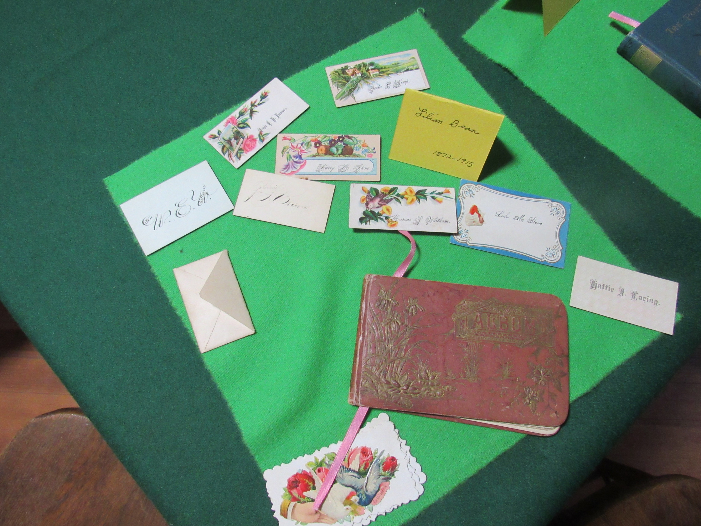 Photograph of Lilian Bean calling cards and album display, labeled 1872–1915.