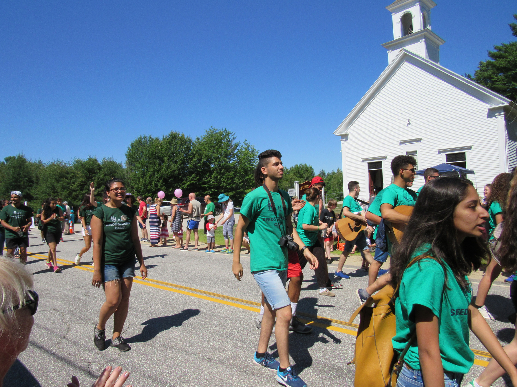 Parade marchers in green shirts at the Fourth of July parade.
