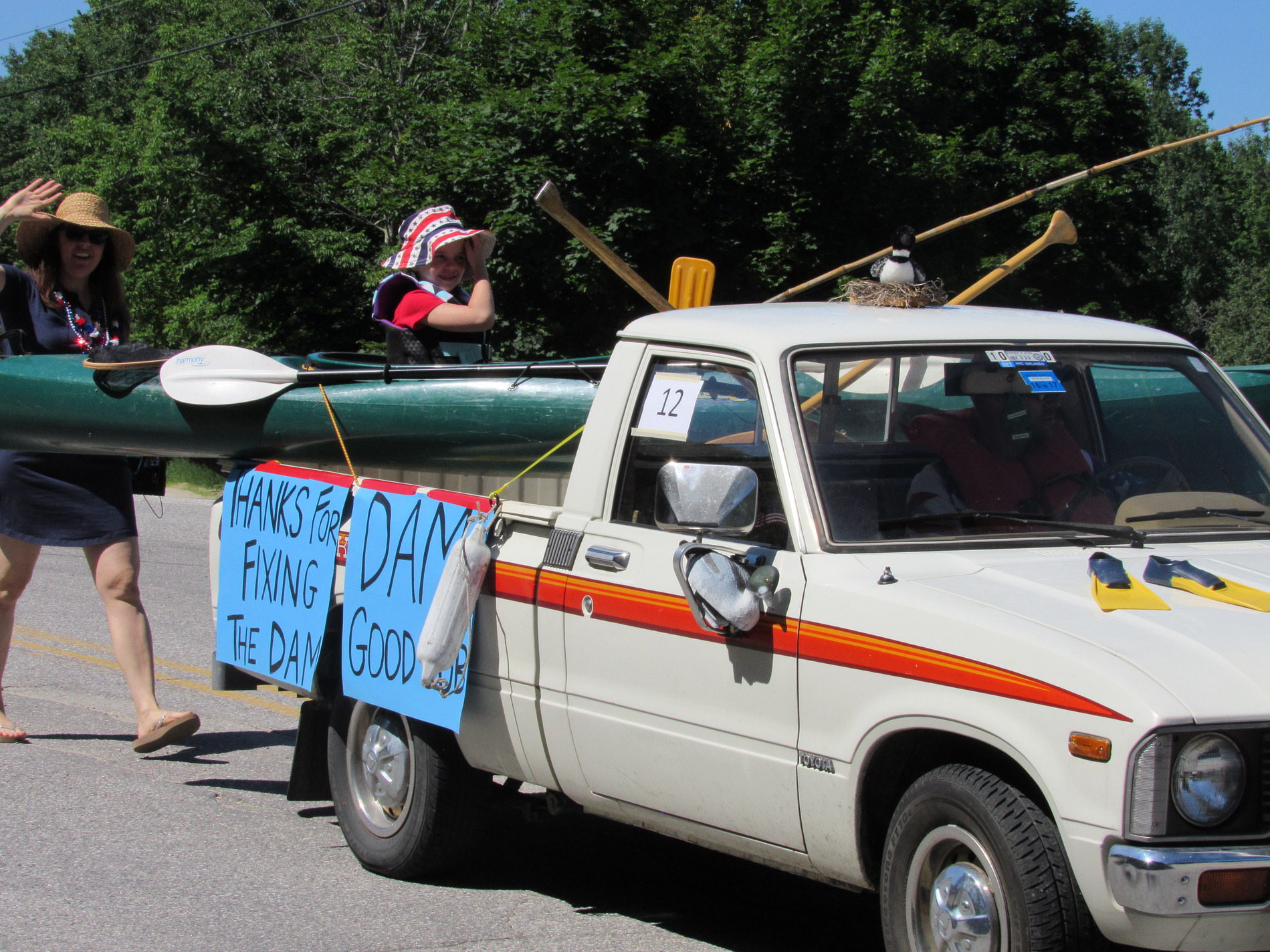 Pickup truck carrying a canoe and Pleasant Lake signs at the Fourth of July parade.