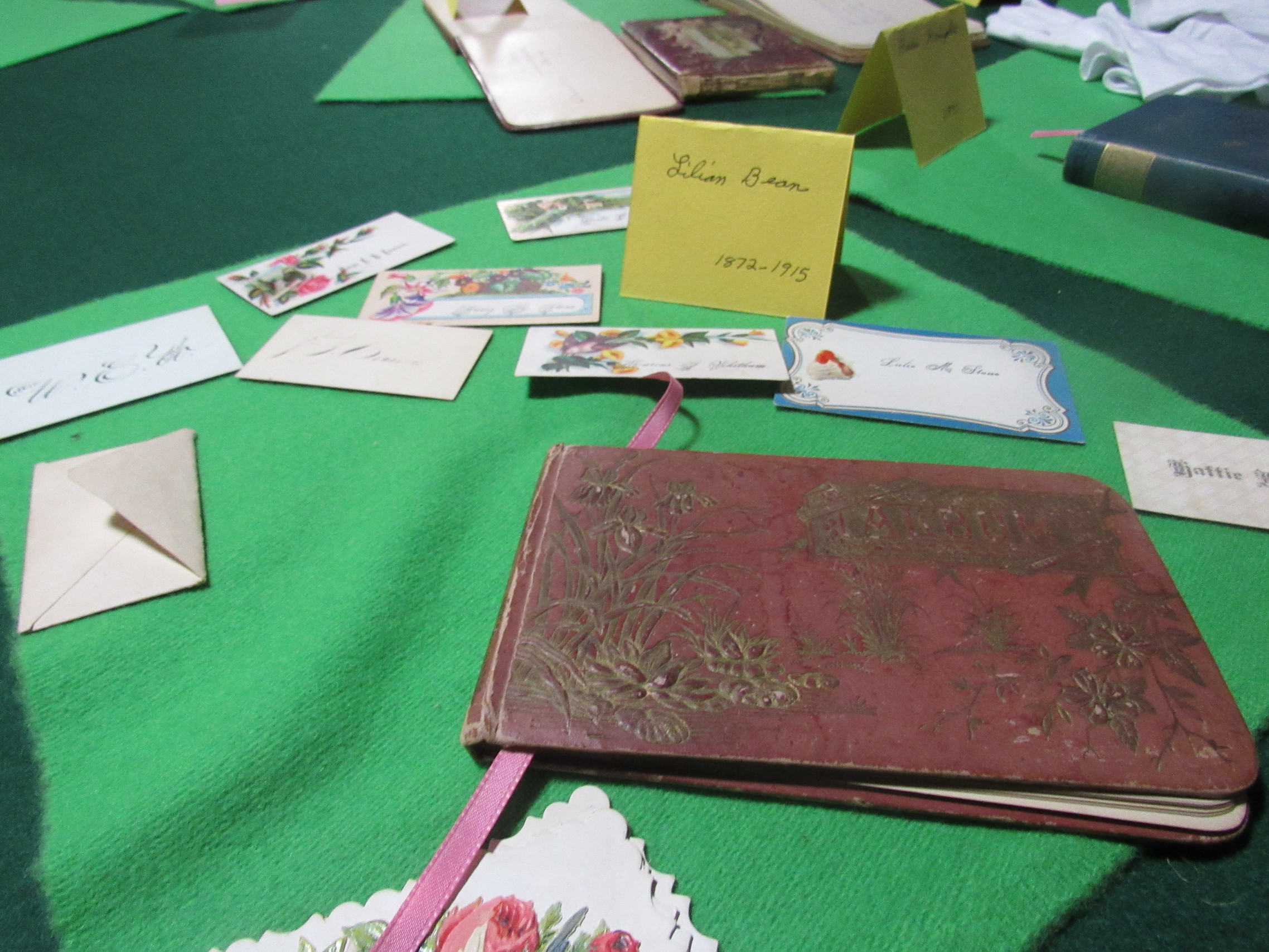Photograph of Lilian Bean calling cards and album display, labeled 1872–1915.