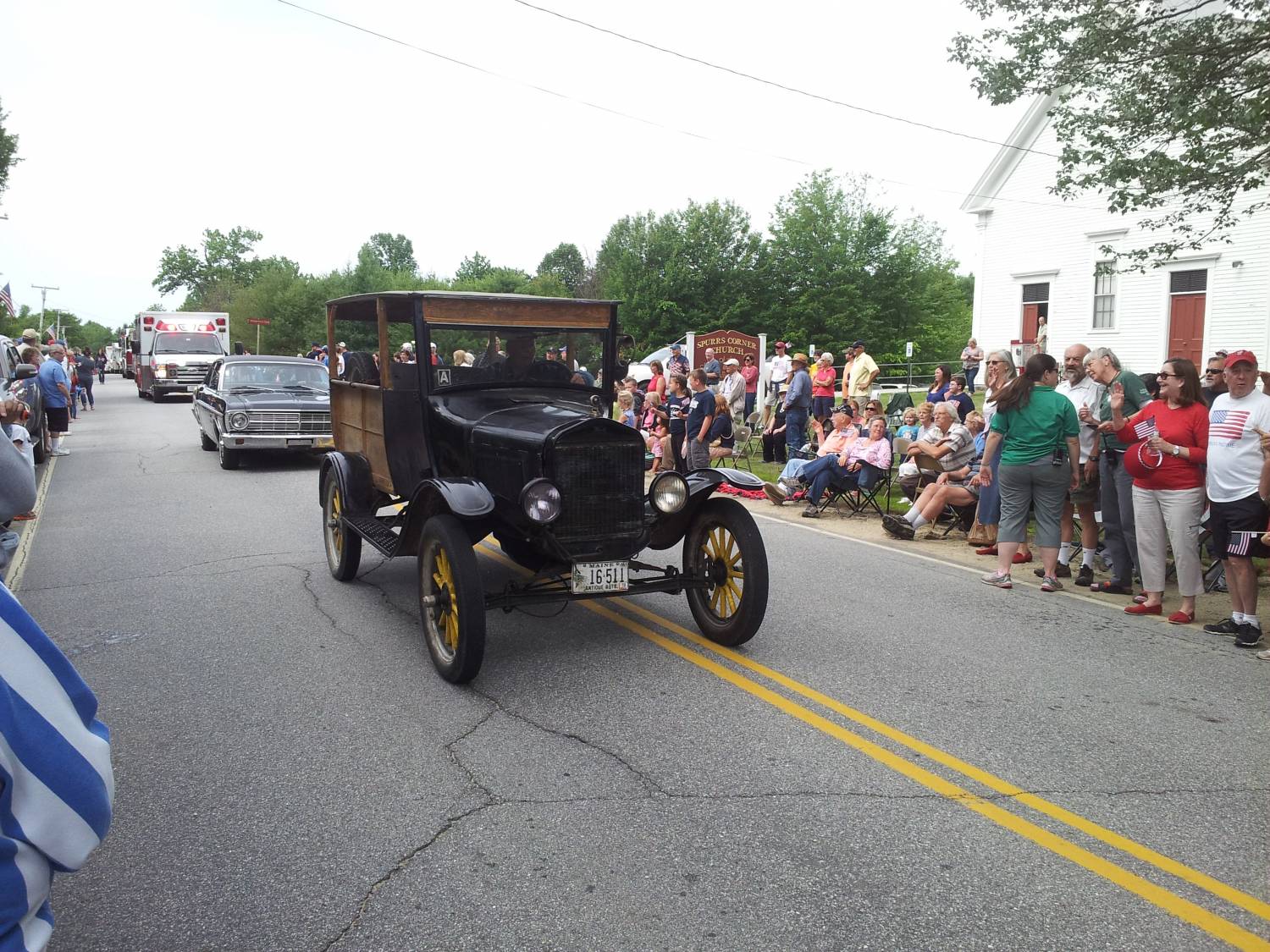 Antique vehicle with a wooden passenger body at the Fourth of July parade.