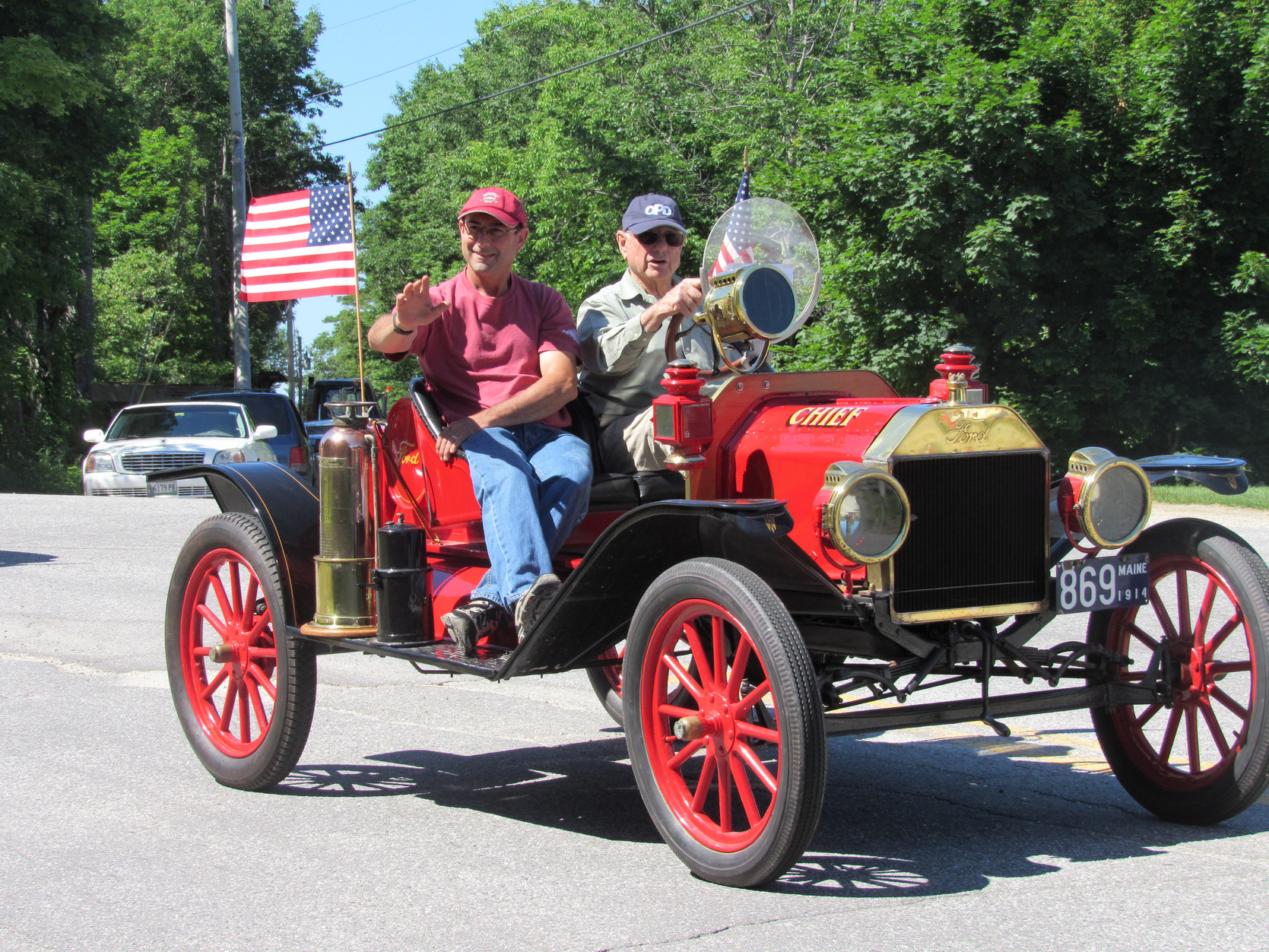 Small antique-style red automobile at the Fourth of July parade.