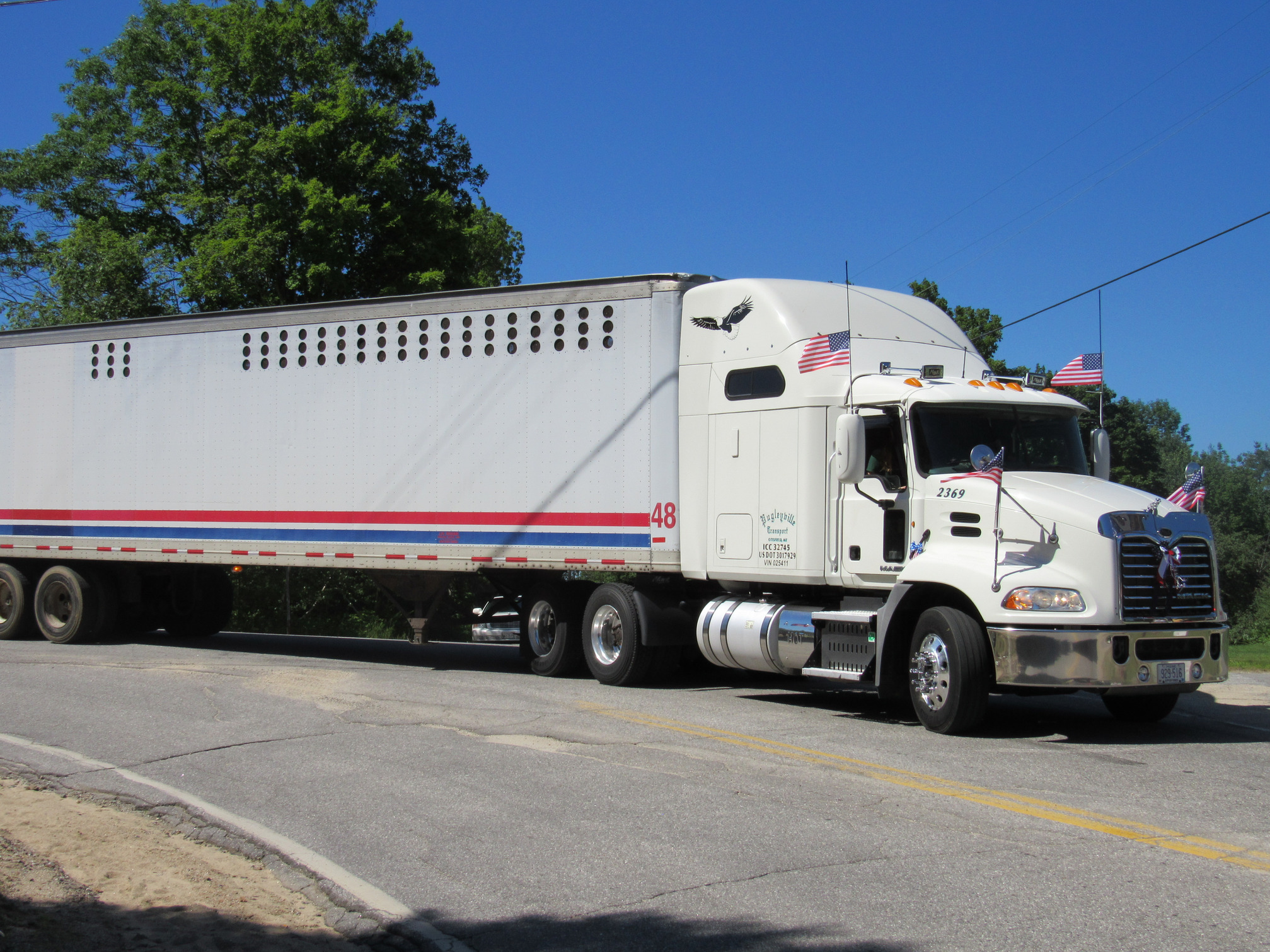 White tractor-trailer in the parade at the Fourth of July parade.