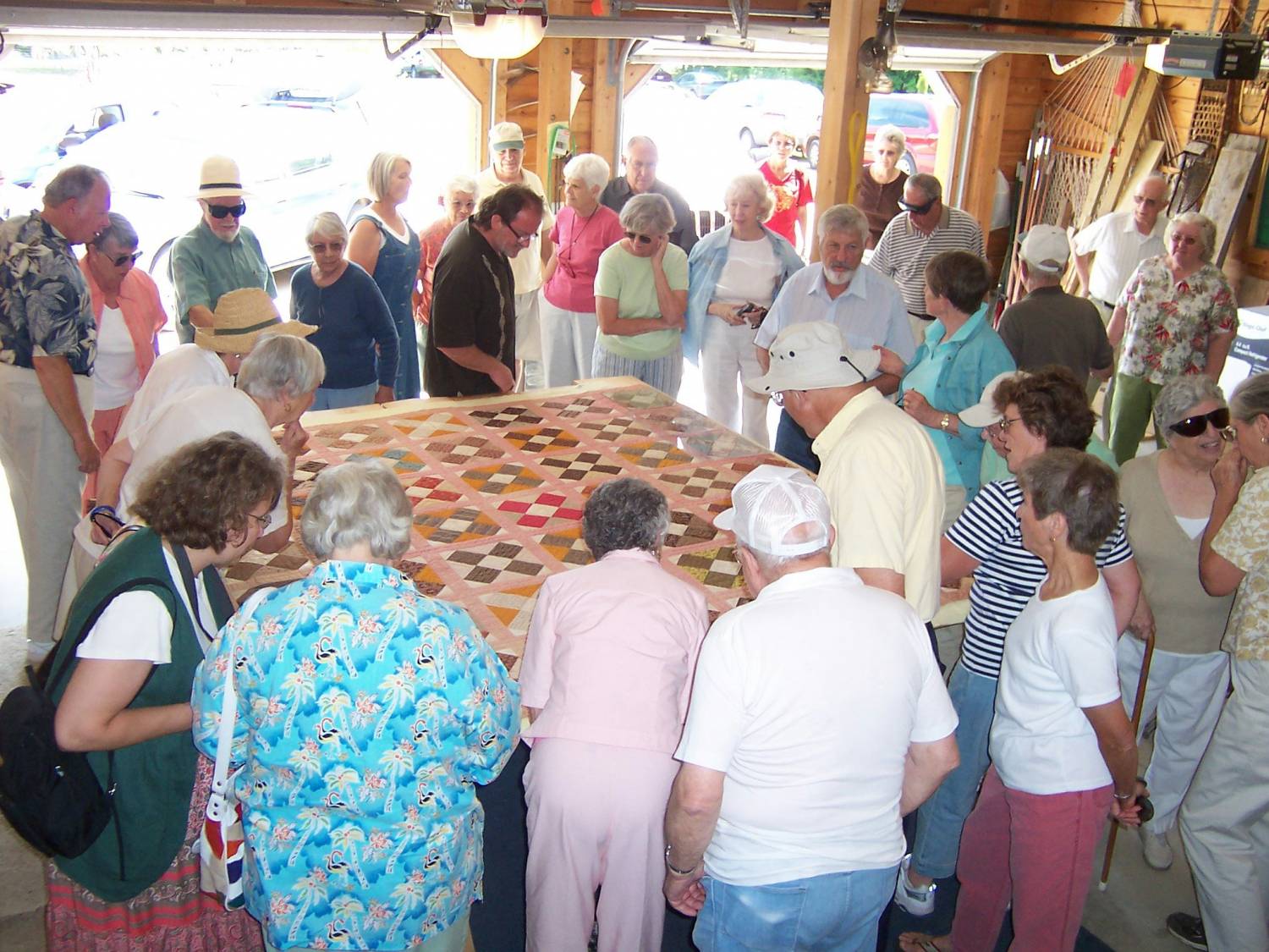 Group inspecting “Friendship Quilt” at OHS meeting, Henry and Shirley Hamilton’s