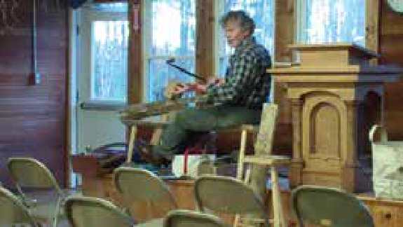 Special guest Ed Somers demonstrating, with a drawknife, the technique used to remove bark from a piece of wood.