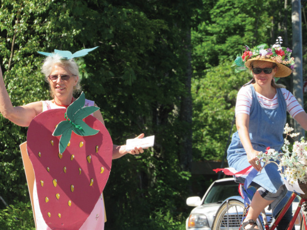 President Shirley Hamilton and a volunteer hand out reminders for the upcoming Strawberry Festival in last years 4th of July Parade