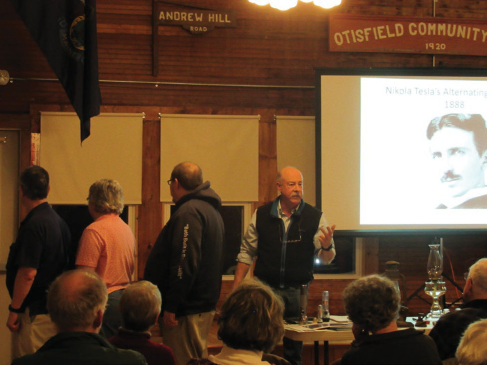 Presenter Jim Howard, demonstrating the differences between alternating and direct current with assistance from David and Celeste Hyer and Tom Peaco