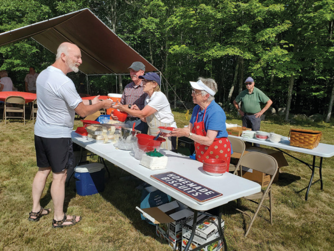 Jean Hankins, Maureen Howard and Jim Howard serve a guest at our annual Strawberry Festival at the Bell Hill Meetinghouse