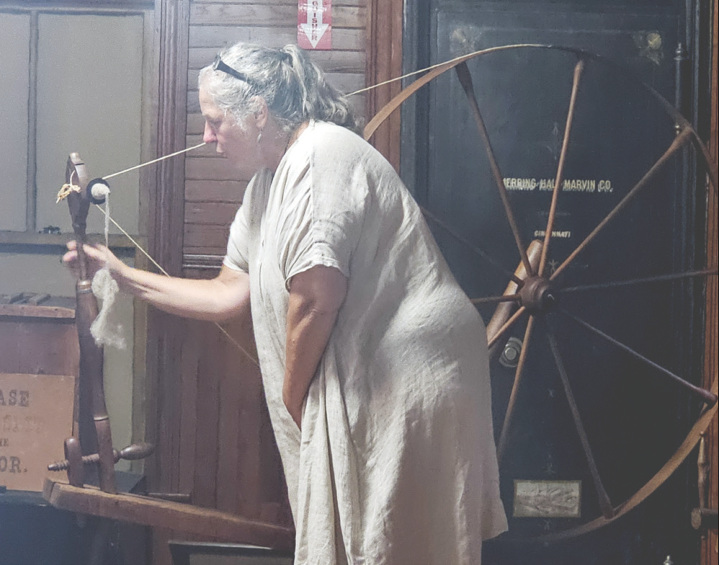 Textile Historian, Cheryl Callahan, demonstrating the technique used to spin fibers into thread